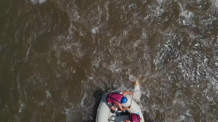 Slow motion group of people rafting on a mountain river. Aerial view group of friends rafting on mountain river. Extreme water sport.