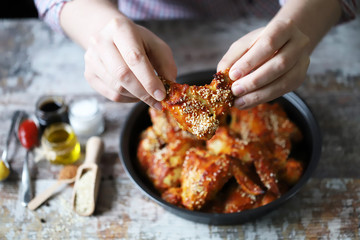 Selective focus. A man eats buffalo wings. Buffalo chicken wings in tomato chili sauce.