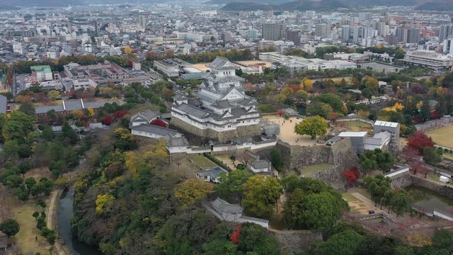 Aerial view of famous Himaji Castle, picturesque autumn scenery with medieval fortress complex and trees of many colors - landscape panorama of Japan from above, Asia