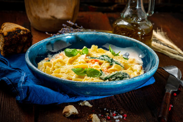 Seafood pasta with shrimp and Basil in cream sauce on a plate on a wooden background