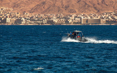 Fototapeta premium Pleasure motor boat in the Red Sea near Eilat - Israeli southernmost and famous resort tourist city, located on the northern shores of the Red Sea