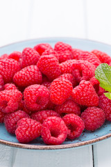 Fresh raspberries in a plate on a  vintage background.