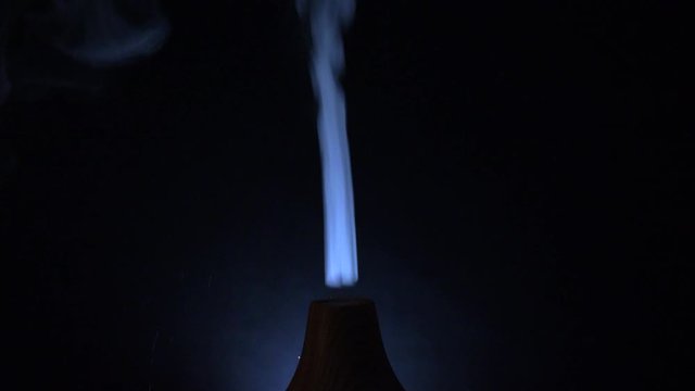 Beautiful Blue smoke coming From  humidifier illuminated With black background - Close up Shot