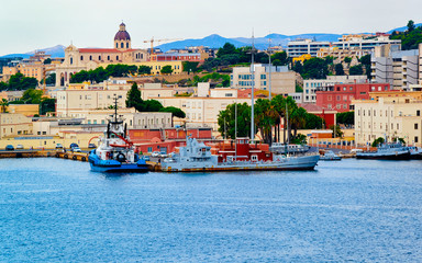 Old Sardinian Port with ships at Mediterranean Sea and city of Cagliari, South Sardinia Island in...