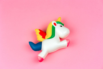 top view squishy unicorn toy on a pastel pink background - obrazy, fototapety, plakaty