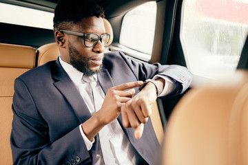 Man looks at his apple watch while being in the car. - obrazy, fototapety, plakaty