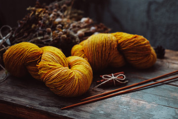 Bright yellow wool yarn skeins in rustic background