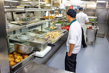 Kitchen crew work in the galley of a cruise ship in the Caribbean Sea