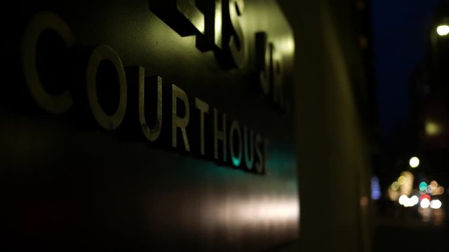 Close up of a courthouse sign in downtown city area - dramatic suspense crime movie shot - Version 2