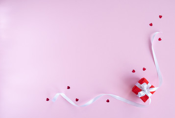 Valentines day composition. Flat lay with gift present box , red hearts, white ribbon on pink background. Top view, copy space. Greeting card. Valentine's day, birthday, wedding concept. 