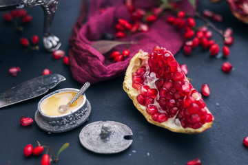 Red slice of pomegranate on a dark table with silver and red elements