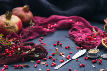 Empty black table with red props and autumn fruits, blank flat lay scene.