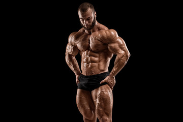 Fototapeta na wymiar Bodybuilder man isolated on the black background. Strong male naked torso abs