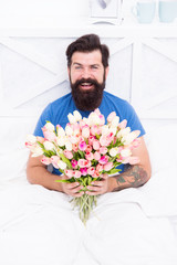 relaxing in morning. positive mood and happiness. happy bearded man in bed. birthday gift bouquet. spring fresh tulip. love valentines day. womens day. tulip flower for march 8. good morning flowers