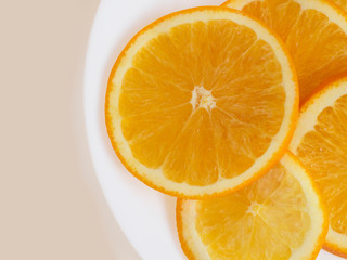 Top view of a plate with sliced orange on white background.