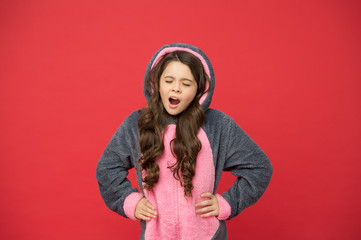 Sleepy and yawny. Sleepy baby red background. Sleepy child wear pajamas red background. Sleepy girl give long yawn. Bedtime. Bed time. Home clothing. Leisure wear. Fashion and style