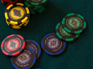 Poker chips on green cloth table in casino gambling chance