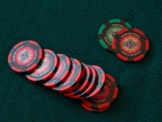 Poker chips on green cloth table in casino gambling chance