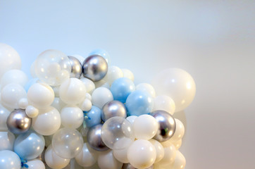 many colored balloons forming a bright background wallpaper image. white. silver. blue balloons as textured backdrop.