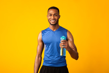 Healthy afro guy with fit body holding bottle of water