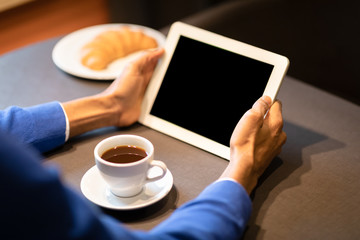 Afro man with tablet reading news in cafe shop