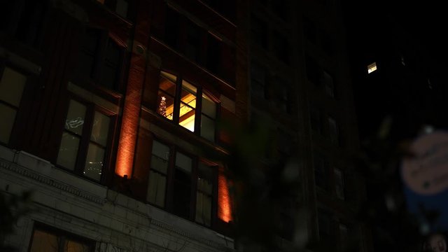 A night apartment building in city area - suspense style establishing shot with foreground motion