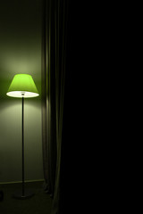 floor lamp stands near curtains