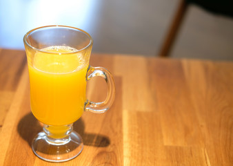 A glass of orange juice on wooden table