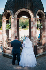 Bride and groom near the little chapel