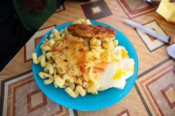 Breakfast. Dinner. Pasta with fried eggs. Fried chop.