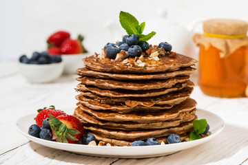 stack of homemade pancakes with fresh berries for breakfast