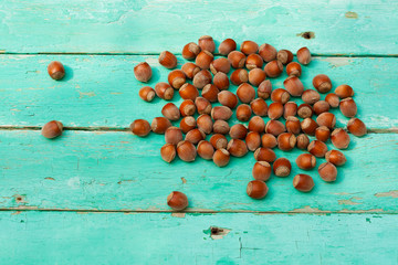 Naklejka na ściany i meble stack of hazelnuts or filbert on rustic turquoise surface