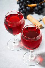 two glasses of red wine on a gray table, vertical closeup