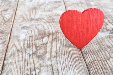 red wooden heart on the background of old boards