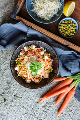 Easy vegan salad with boiled green peas, fresh parsley root slices and carrot, smoked tofu and topped with Alfalfa sprouts