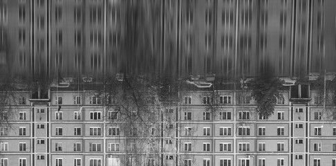 Many windows on apartment house in small town with reflection. Gray dull background. Local lifestyle and architecture