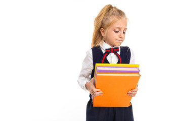 Young schoolgirl with blonde hair holds a lot of books isolated on white background