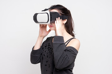 a young girl uses virtual reality glasses on a white background