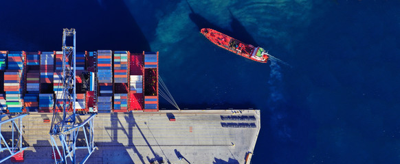 Aerial drone ultra wide top down photo of commercial container terminal with cranes loading...