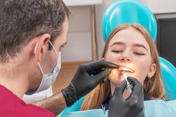 doctor applies the medicine to tooth
