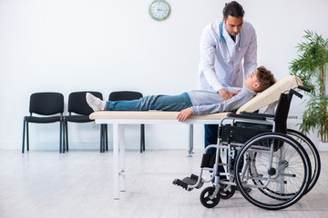 Young male doctor pediatrist and boy in wheel-chair