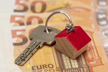 Schlüsselbund mit Anhänger liegt auf 50 Euro Geldscheinen