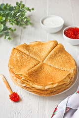Stack of russian pancakes (crepes) with red caviar and sour cream. Traditional Maslenitsa (Shrovetide) meal.