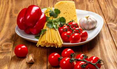 Naklejka na ściany i meble Italian cuisine. Ingredients for cooking Italian pasta - spaghetti, tomatoes, peppers, garlic and herbs.