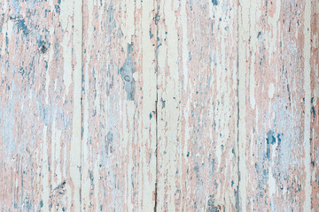 Flaking pink-blue paint on a faded wooden background