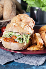 Pulled chicken sandwich with salad and bbq sauce
