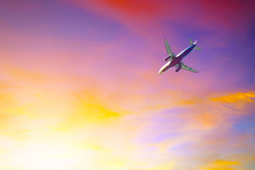 Fototapeta na wymiar Passenger plane flying in colorful sky at sunset