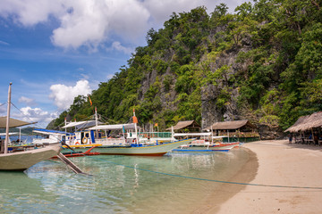 Fototapeta na wymiar Traditional wooden Filipino boats by the beach of a small island in the sea, Coron Palawan Philippines