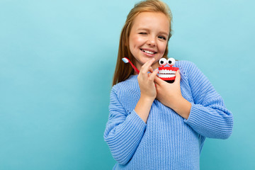 Teenager girl with tooth brush recommends brushes teeth