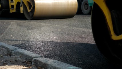 Heavy roller stack and press hot asphalt. Yellow road repair machine. Paver machine lay new bitumen on roads